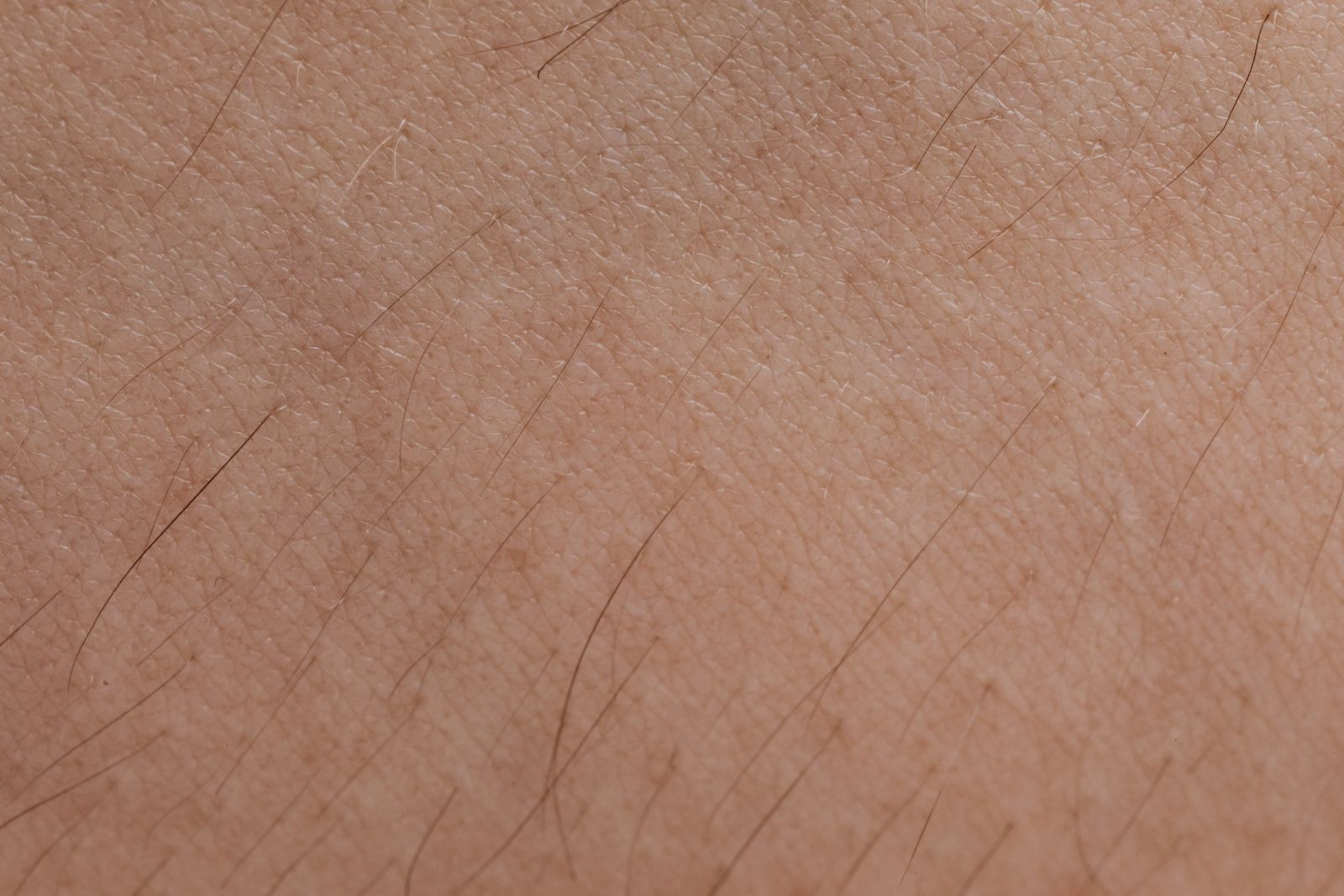 Close-up of hairs growing from skin, answering does shaving make hair grow back thicker