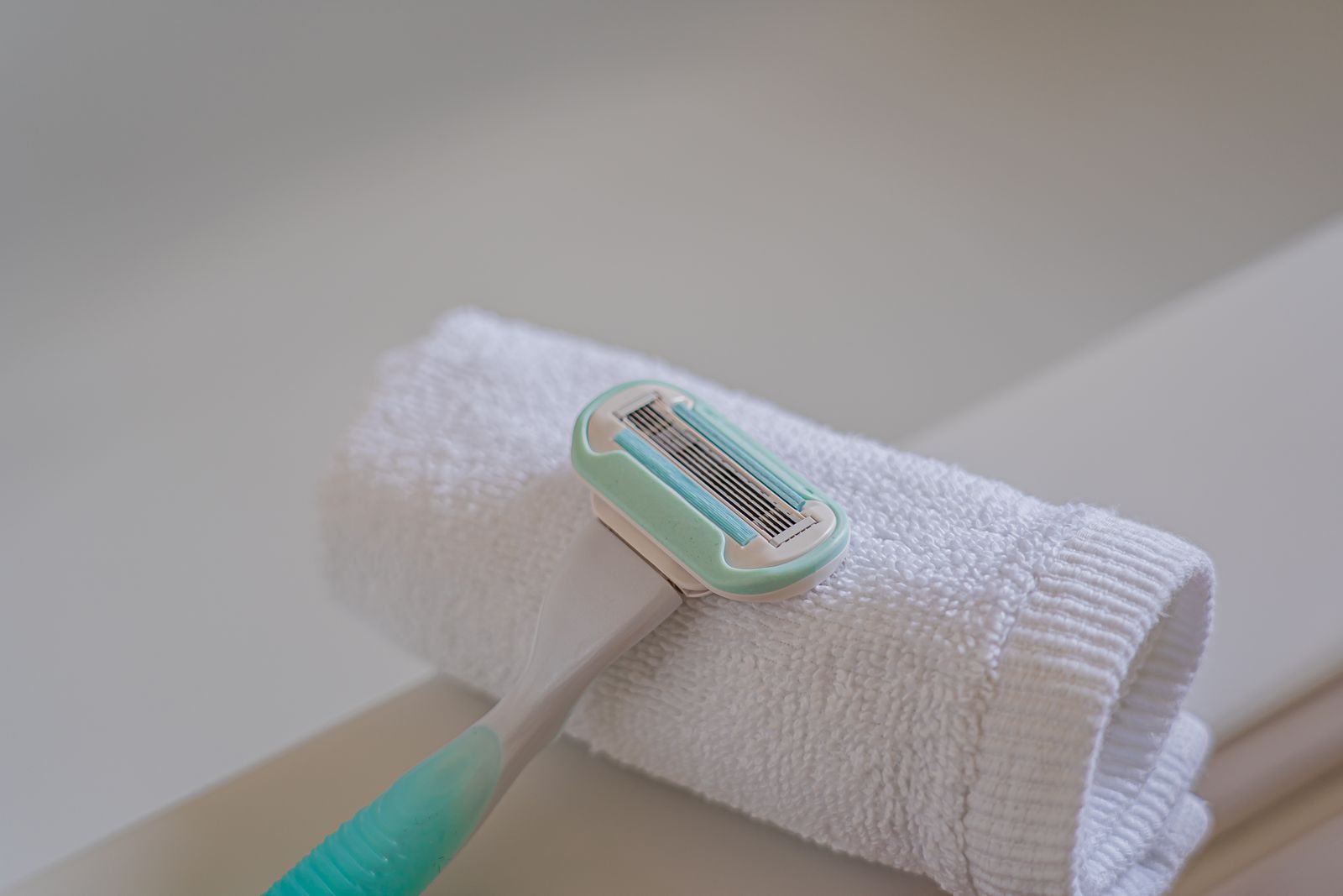 How often should you shave: a disposable razor resting on a rolled white towel