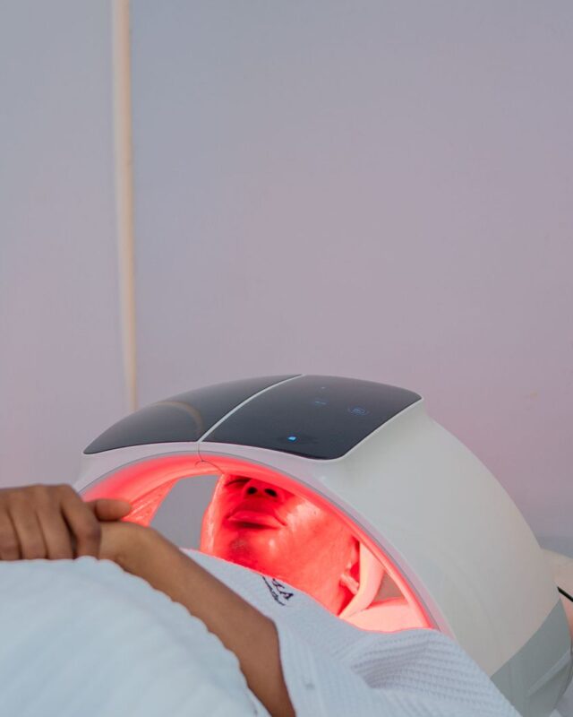 How often should you use red light therapy: a client lying under a red LED light therapy dome