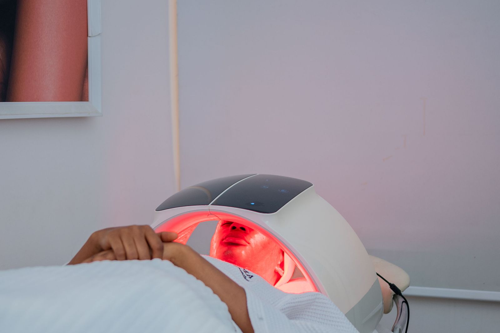How often should you use red light therapy: a client lying under a red LED light therapy dome