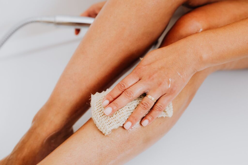 Gentle loofah exfoliation on a wet leg, one way to get rid of strawberry legs