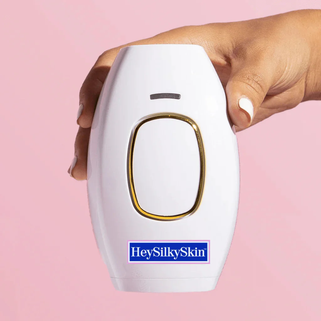 How to use the HeySilkySkin IPL handset: the white handset held in one hand against a pink background